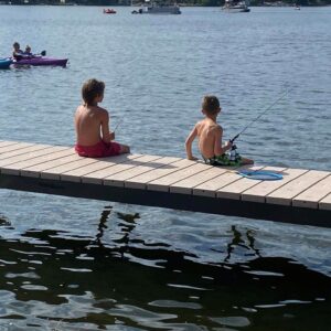 Two boys fishing off the side of a V-Dock